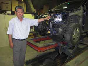 車体のゆがみを測定する機械を前にした尾又氏