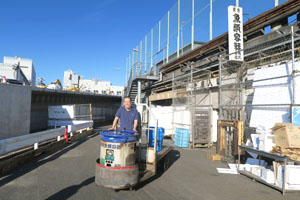 市場を移動するターレットトラックに乗る原氏